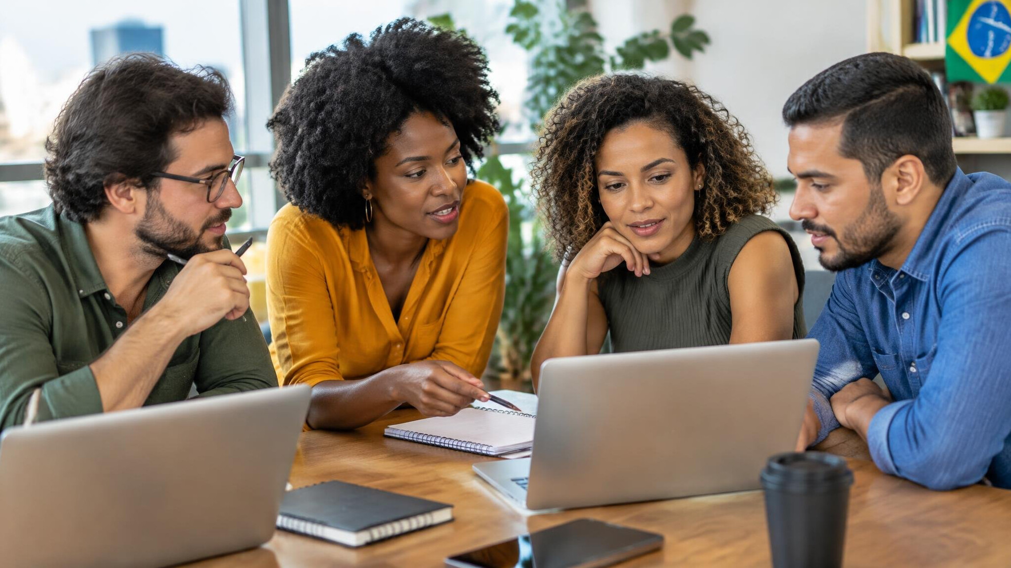 Team of people collaborating at a table with laptops